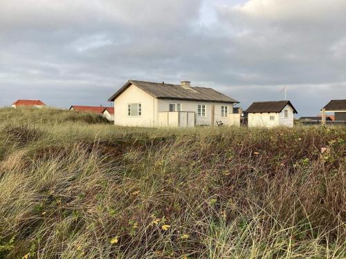 a house sitting on top of a grass covered field at 4 person holiday home in Frøstrup in Frøstrup
