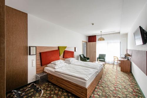 a bedroom with a bed and a table and chairs at Hotel Lenart in Wieliczka