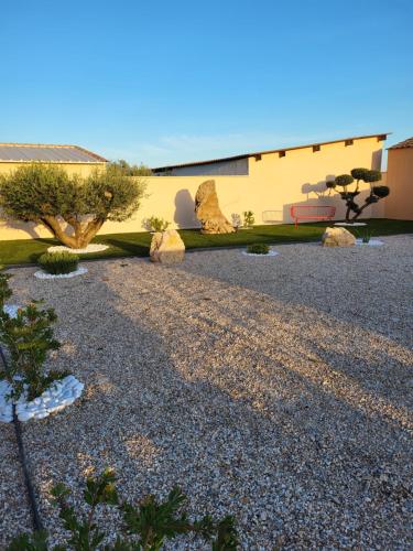 a garden with rocks and trees and a building at Pissenlit Une Prairie en Provence in Arles
