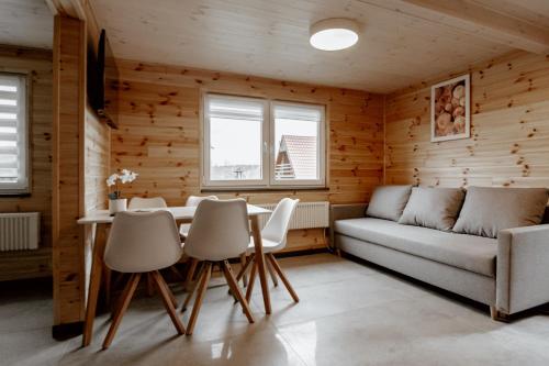 a living room with a couch and a table and chairs at Sudecki Domek in Kudowa-Zdrój