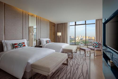 um quarto de hotel com duas camas e uma televisão de ecrã plano em The Ritz-Carlton, Baku em Baku
