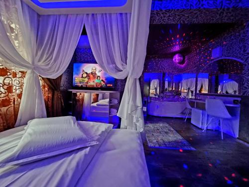 a bedroom with a bed and a bar with purple lights at Hotel Boutique Mikaela (Adult Only) in Braşov