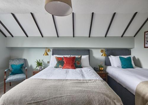 a bedroom with a large bed with colorful pillows at The New Inn Heckfield in Hook