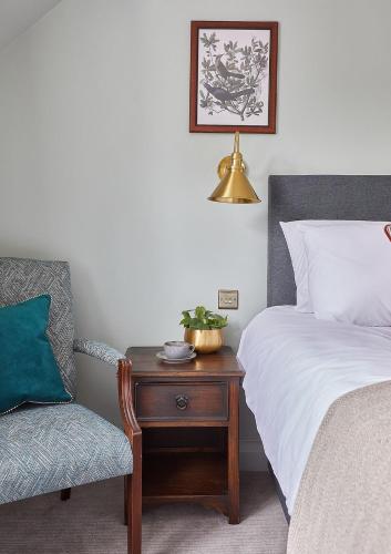 a bedroom with a bed and a table with a chair at The New Inn Heckfield in Hook