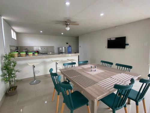 a dining room with a wooden table and chairs at Tumbes Zorritos Bocapan Casa con piscina 3 dormitorios in Bocapán