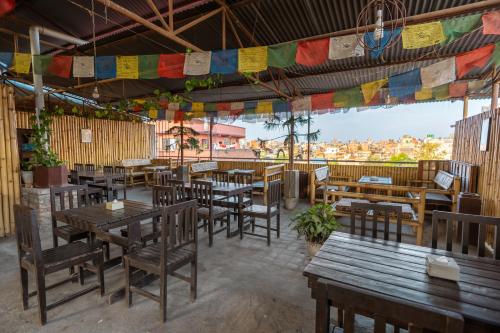 restauracja z drewnianymi stołami, krzesłami i flagami w obiekcie Mystic Homes Hotel w Katmandu
