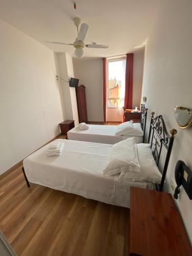 two twin beds in a room with a window at Hotel San Giorgio in Bologna