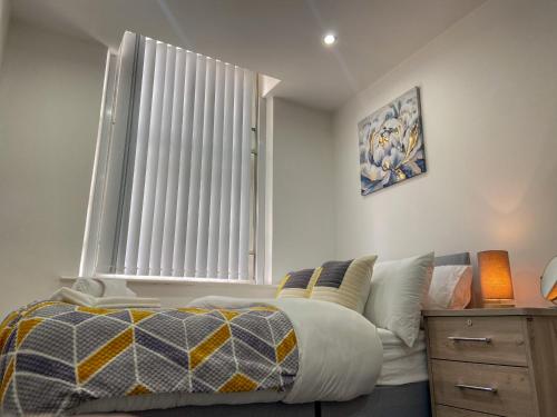a bedroom with a bed and a large window at Urban Retreat - Bradford Apartment Gem in Bradford