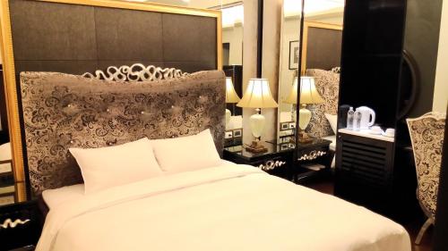 a bedroom with a large white bed and a large mirror at Hotel Modern Puli in Puli