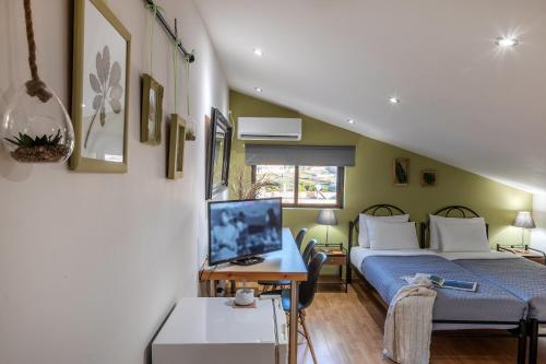 1 dormitorio con 1 cama y escritorio con TV en Jo Marinis Rooms, en Korinthos