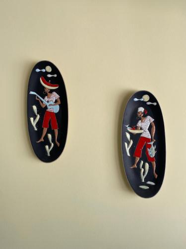 a couple of black plates with a picture of a man on a wall at Casa da Fonte - Vintage House and Rooftop in Figueira da Foz