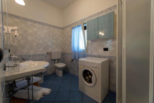 a bathroom with a washing machine and a sink at Pugnochiuso Resort Villette Belvedere in Pugnochiuso