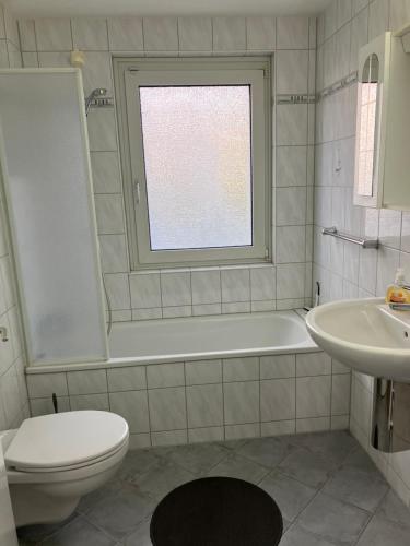ein weißes Bad mit einem WC und einem Waschbecken in der Unterkunft Abelia Gästehäuser in Helmstedt