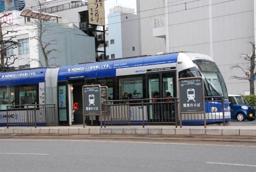 a blue and white bus on the side of the street at Okayama Koraku Hotel in Okayama