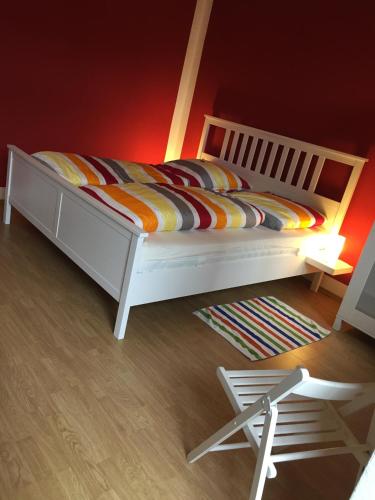 a bedroom with a white bed and a red wall at Im Herzen - Zentral in Leipzig in Leipzig
