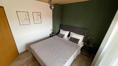 a bedroom with a bed and a green wall at Apartments San in Sukošan
