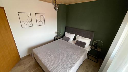 スコシャンにあるApartments Sanのベッドと緑の壁のある寝室
