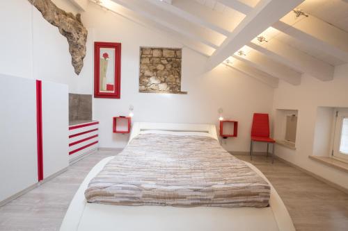 a bedroom with a large bed and a red chair at Ca' Del Jago Sole Luna apartment in Negrar