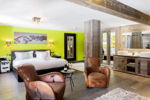 a bedroom with a bed and chairs and a bathroom at Hotel Farinet in Verbier