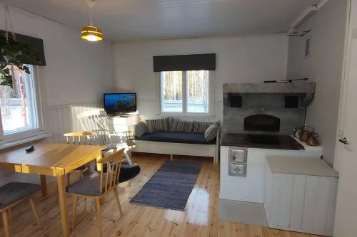a kitchen and living room with a couch and a table at Villa Mäntysaari luonnonrauhaa kaupungin lähellä. in Kontiolahti