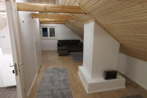ein Wohnzimmer mit einem Sofa und einer Holzdecke in der Unterkunft Villa Mäntysaari luonnonrauhaa kaupungin lähellä. in Kontiolahti