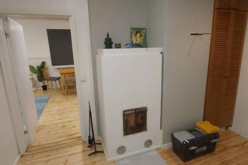 a white refrigerator in a room with a wooden floor at Villa Mäntysaari luonnonrauhaa kaupungin lähellä. in Kontiolahti