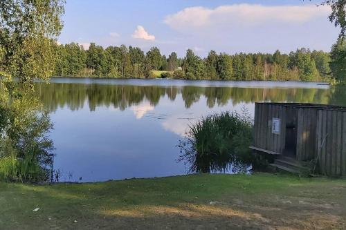 a small shack sitting on the edge of a lake at Villa Mäntysaari luonnonrauhaa kaupungin lähellä. in Kontiolahti