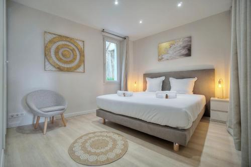 une chambre avec un grand lit et une chaise dans l'établissement ELEGANT DUPLEX 5 CHAMBRES PLAGES du MIDI A5B03, à Cannes