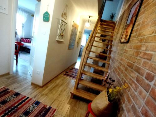 a staircase in a living room with a brick wall at Pokoje goscinne u Olguni in Chyrowa