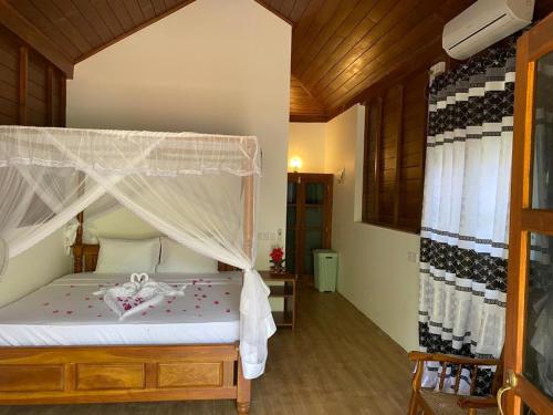 1 dormitorio con 1 cama con dosel en Hanguk Lanka Lagoon Villa en Tangalle