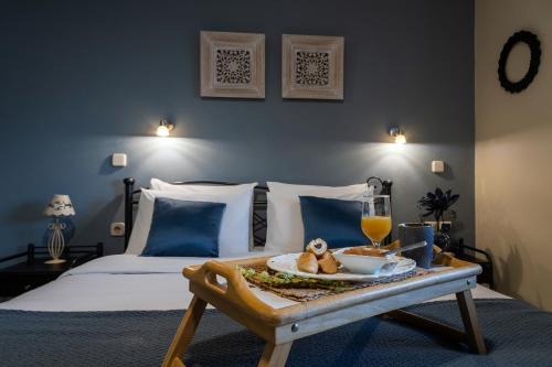 a bedroom with a bed with a tray of food on a table at Jo Marinis Rooms in Korinthos