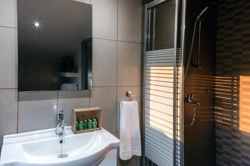 a bathroom with a white sink and a shower at Jo Marinis Rooms in Korinthos