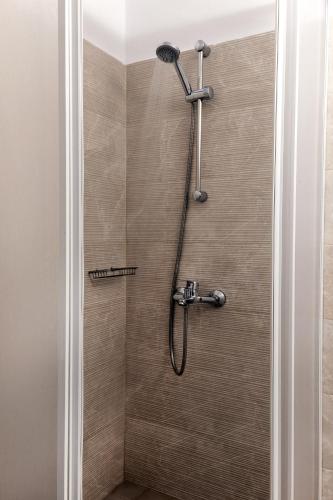 a shower with a shower head in a bathroom at Jo Marinis Rooms in Korinthos