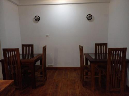 a dining room with wooden chairs and a table and a table and chairsktop at Heart of the Hill in Nuwara Eliya