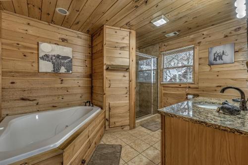 Cabaña de madera con baño con bañera y lavamanos en Cozy Blue Ridge Cabin in Heart of the Mountains, en Blue Ridge