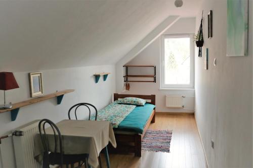 a bedroom with a bed and a table and a window at Dom prywatny in Przesieka