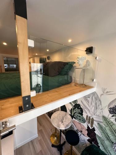 un salon avec un canapé vert et une table dans l'établissement The GARDEN - cosy studio with AC in the very center of Paris, à Paris