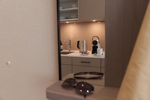 ein Badezimmer mit einem Spiegel, einem Waschbecken und einer Theke in der Unterkunft CITY STAY - Franklinstrasse in Zürich