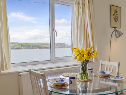 a dining room with a glass table and a window at Cliff Cottage - Uk43207 in Dale