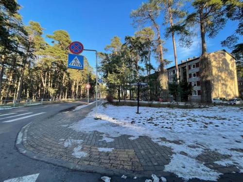 een met sneeuw bedekte straat met een bord aan de kant van de weg bij Апартаменты, Юрмала in Jūrmala