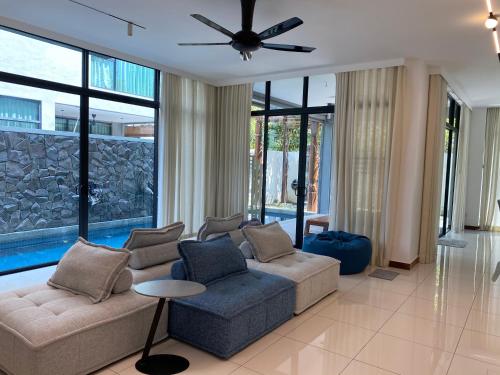 a living room with a couch and a ceiling fan at Ikiru 18 Private Saltwater Pool Villa, 3 Ensuite BR, Outdoor BBQ, 5 mins to Beach in Pantai Cenang