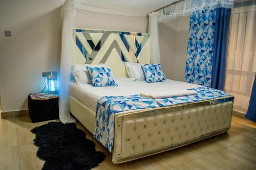 a bedroom with a bed with blue and white pillows at The Fancy Luxurious 3 bedroom apartment in Nakuru