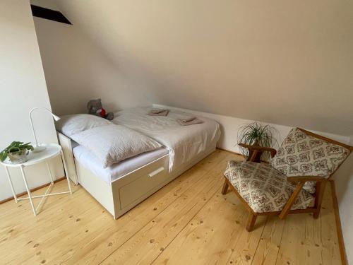 um pequeno quarto com uma cama e uma cadeira em Chaloupka v Pošumaví em Sušice