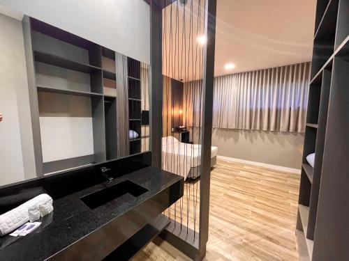 uma casa de banho com um lavatório e um espelho em Eleganz Hostel & Suítes em Gramado