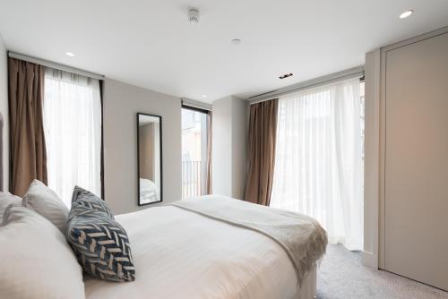 una camera da letto con un grande letto bianco e finestre di New Build-Air Con-2 Bedroom-Two Bathrooms Apt 3 a Londra