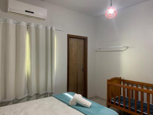 1 dormitorio con cama, ventana y cuna en Casa Riqueza da terra, en Lucas do Rio Verde