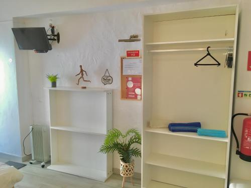 um quarto com prateleiras brancas e um vaso de plantas em Villa Marias - Ferragudo em Ferragudo