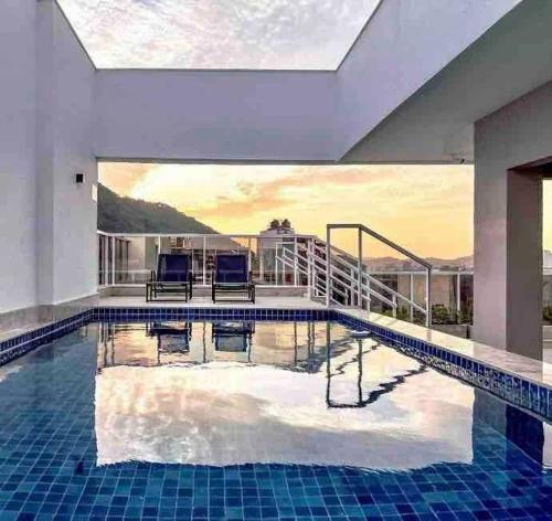 uma piscina com duas cadeiras numa casa em Stúdio Elegance Central - Av Itamar Franco em Juiz de Fora