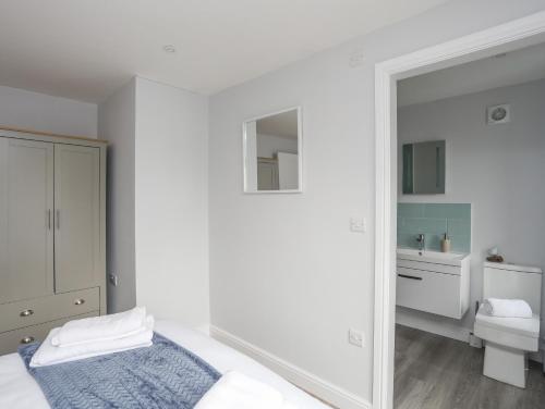 Habitación blanca con cama y baño. en Tan Y Coed - Nasareth en Caernarfon