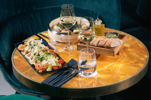 a table with a tray of food and glasses of wine at Le Méridien Vienna in Vienna